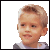 A pixelated image of a child with light brown hair wearing a gray and white shirt, shown in two side-by-side where the right has overlaid text