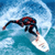 Pixelated static image of a surfer riding a wave on a white surfboard against blue water background.