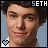 Four- of a person with dark curly hair against light blue background, each showing slight variations in facial expression and head position