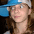 A pixelated image shows a person with long brown hair wearing a blue and white cap, next to bold text on a solid blue background.