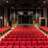 Pixelated static image showing a red carpeted area with dark upper sections and indistinct shapes in the background.