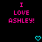 Pixelated text "I LOVE ASHLEY!" in bright pink on black background with cyan heart symbols below.