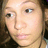 Pixelated close-up of a person's face with light skin tone, brown hair visible on the right side, and neutral expression.