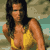 Static pixelated image of a woman in a yellow bikini top against a beach background with muted tones and visible dithering.