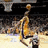 A basketball player in a yellow jersey shoots a ball while another player in a white jersey defends, with a crowd in the background and text below reading "future hall of famer".