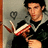 A pixelated image shows a person in a black shirt holding a red and white striped object against a gray background with a dark circular symbol.