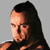 Pixelated static image of a person with long dark hair and light skin in profile view against gray background