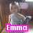 A child in a silver dress sits on a wooden chair with a pink 'Emma' text overlay, blue ':D' emoji, and red '<3' symbol