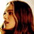 Pixelated static image of a person's profile with long brown hair and light skin tone, cropped to show head and shoulders against a white background.