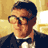 Pixelated static image of a man in formal attire with glasses against a yellow background, likely from an animated film or series.