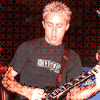 showing a person in a black t-shirt playing an electric guitar, with text overlays changing between 'MAYBE IT'S CHILDISH' and 'AND MAYBE IT'S WRONG'