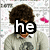 A person with curly brown hair wears a light gray hoodie, standing against a patterned background while text overlays change sequentially.