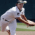 Pixelated image of a baseball player in white uniform pitching on field with dark background.
