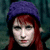 A pixelated image of a person with red hair and a purple beret, next to the word DECODE in blocky white letters on a black background.