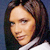 Pixelated close-up of a person with long dark hair wearing a white top against a dark blue background.