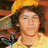 Pixelated image of a person with curly hair wearing a yellow hat and shirt, split into four quadrants with text overlays on two sections.