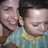 Two pixelated figures in close proximity, one with dark hair and a light blue shirt, the other with light hair and a yellow shirt, both with closed eyes and smiling expressions.