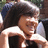 Pixelated image of a person with dark hair wearing white and black clothing, cropped closely to the upper body.