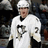 Pixelated image of a person wearing white sports jersey with dark number 17, black collar, and white helmet against blurred background.