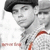 Pixelated grayscale image of a person wearing a dark cap and light jacket with red accents, partially cropped on the right.