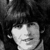 Black-and-white pixelated image of a person with dark hair and a light-colored shirt, cropped to show only the upper face and shoulders.