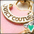 A circular gold-toned badge with 'JUICY COUTURE' text on a pink background, featuring an animated heart that changes color from green to red to blue.