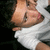 Pixelated close-up of a person with light skin wearing white clothing, dark hair visible on the left side.