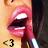 Pixelated close-up of a person's mouth with dark red lipstick, showing lips parted and teeth visible against a light background.
