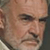 Static close-up of a person's face with pixelated rendering and visible dithering, showing partial facial features including eyes, nose, mouth, and hair against a neutral background.