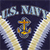 A pixelated icon features 'U.S. NAVY' text above a golden anchor symbol flanked by two white cloud-like shapes on a dark blue background.
