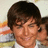 Pixelated static image of a person with short dark hair, closed eyes, and a slight smile, wearing a light-colored shirt against a blurred background.