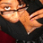 Pixelated close-up of a person with light skin wearing dark clothing, making an exaggerated facial expression with wide eyes and open mouth.