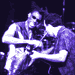 Four- shows purple-toned figures in dynamic poses with instruments and equipment, likely from a live performance