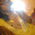 A yellow and brown textured surface with a bright light source casting diagonal shadows, showing subtle pixel variations across four