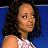 Pixelated image of a person with dark curly hair wearing a white sleeveless top against a blue background.