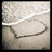 A heart shape drawn in wet sand on a beach, with gentle waves lapping at the shore behind it.