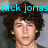 Pixelated image of a person with dark curly hair and light skin, with cyan text reading 'nick jonas' above the head.