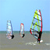 Pixelated static image of three stylized figures on a beach with blue sky and water background, likely representing sports or outdoor activity icons.