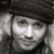 Black-and-white pixelated image of a person wearing a dark cap with text "Please?" above the head, showing two side-by-side facial views.