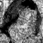 Black-and-white pixelated image of a person with long hair and patterned clothing, partially cropped on the right side.