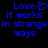 Blue pixelated text on black background reads "Love-❤ it works in strange ways" with heart symbol replacing hyphen.