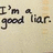Pixelated text on a light beige background reads "I'm a good liar." in dark brown letters with visible pixelation and slight color variation.
