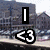 A pixelated image shows a blue and white train with the number 2 on its side, overlaid by black text elements including 'I', '<3', and partial words.