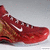 Red and gold Nike basketball shoe with white swoosh logo, displayed in four views showing slight rotation.