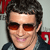 Static pixelated icon of a person with dark hair, orange-tinted sunglasses, and a slight smile against a light background with red accents.