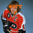 A person in a red and white hockey jersey with black accents holds a hockey stick, wearing orange text overlays that change across frames.