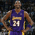 Pixelated image of a basketball player in a purple jersey with yellow accents, standing with hands on hips against a dark background.