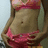 Pixelated image of a person's torso wearing pink bikini top and bottom, with visible navel against light background.