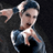 Pixelated static image of a person with dark hair tied back, wearing a blue and white outfit against a black background.