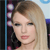 A static pixelated image shows a person with light brown hair styled in a side-swept manner, wearing dark clothing against a blurred background with blue and purple tones.